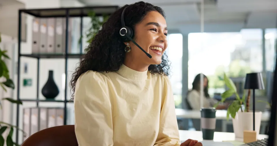 A smiling interpreter working remotely with a headset